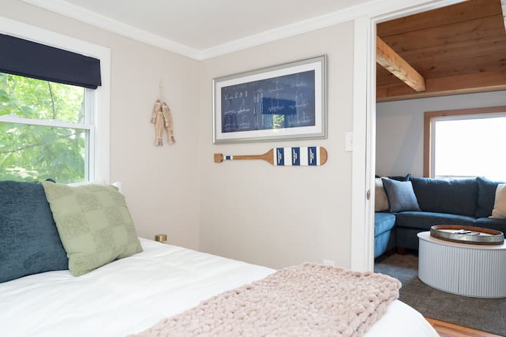 Queen size bed with bedside lamps and charging cubes on either side of the bed. 