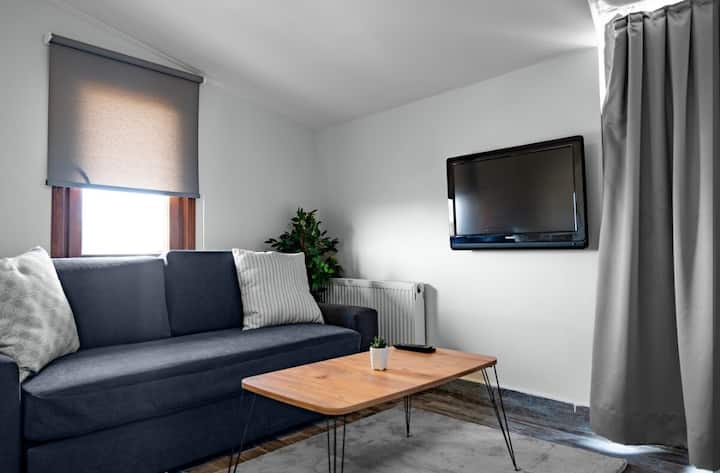 Lichte bovenkamer met een comfortabele bank en tv.