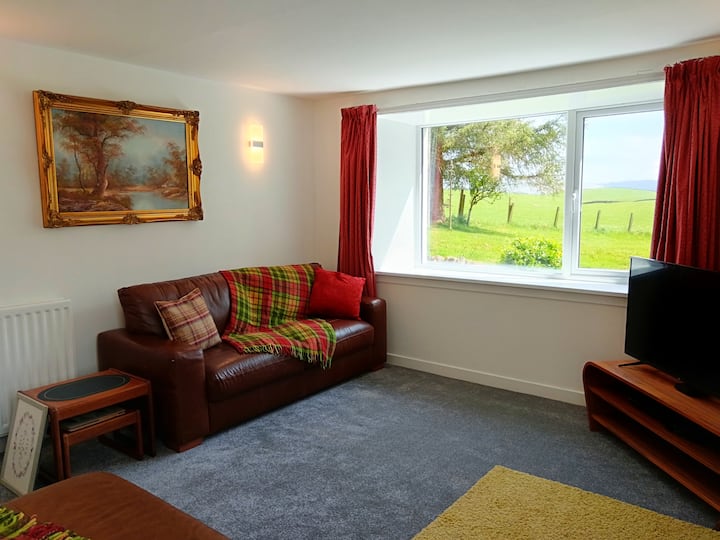 A light and airy room, with view of the open countryside. There is a 3 seater and 2 seater leather sofa, Smart TV with FreeSat and DVD player and a log burner