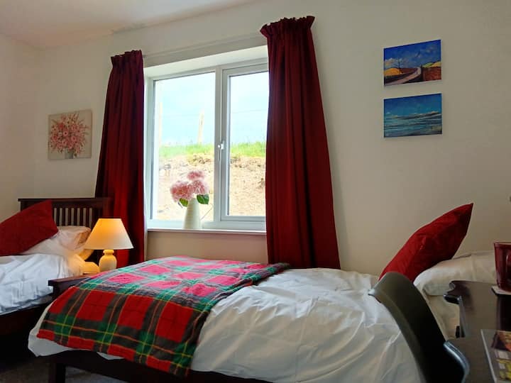 Tastefully decorated bedroom with 2 single beds, a dressing table and inbuilt wardrobe space. 