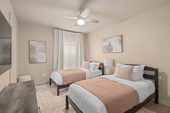 Dormitorio en el segundo piso con 2 camas individuales, TV inteligente de 55 pulgadas y baño privado.