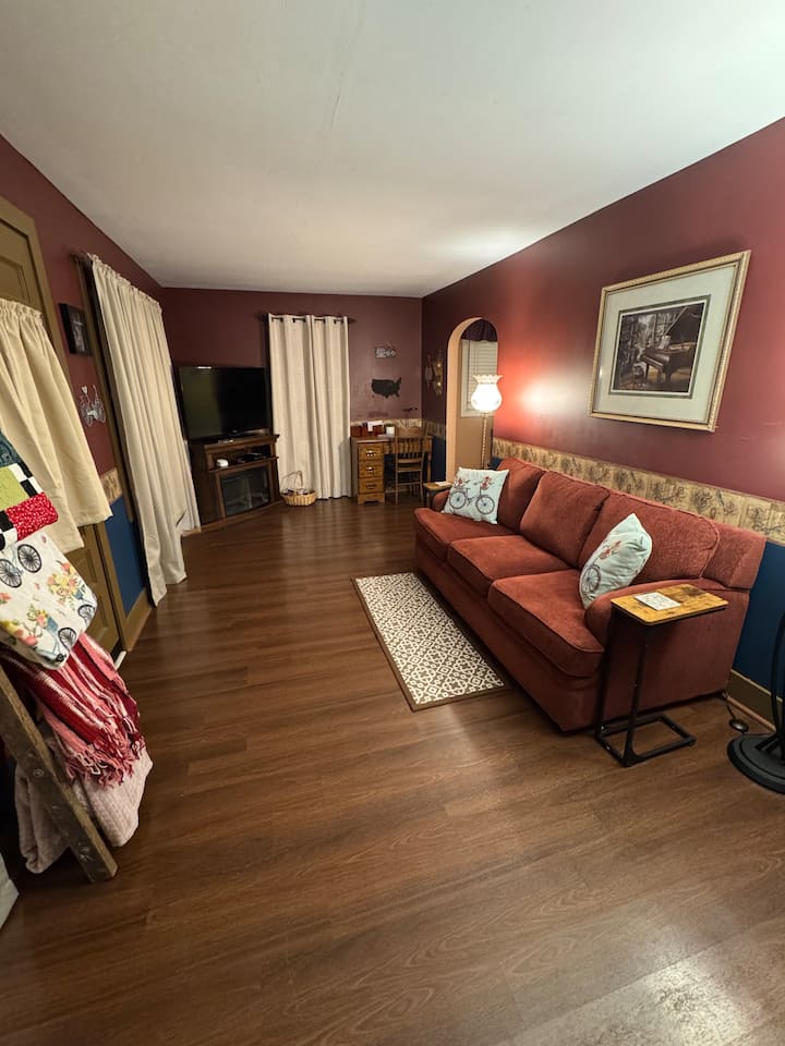 Relájate en nuestra acogedora sala de estar con una chimenea eléctrica para el ambiente. Relájate en el sofá Lazyboy o en las sillas a juego, envuelto en una suave manta, mientras ves una película en el televisor inteligente. Disfruta de un espacio cómodo y acogedor perfecto para el ocio. 