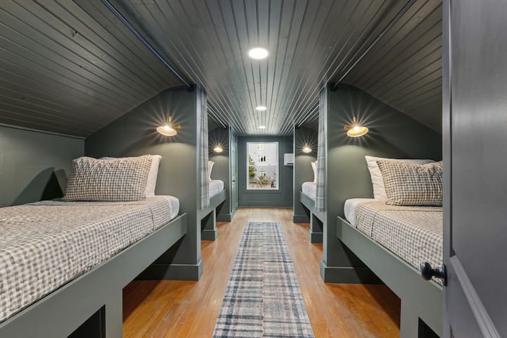 Poschodová izba s poschodovou posteľou, priestorom na batožinu a závesmi pre súkromie. Skriňa, zrkadlo v plnej výške a prístup do kúpeľne.