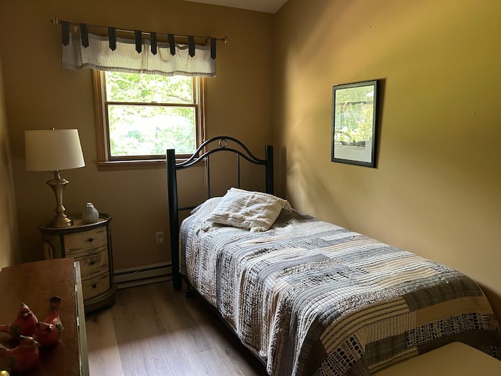 Hiki ni chumba kidogo cha kulala chenye kitanda cha mapacha. 