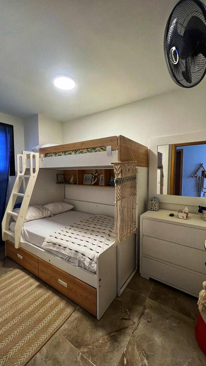 חדר שינה בקומה הראשית עם חדר רחצה ומקלחת ממול לדלת.