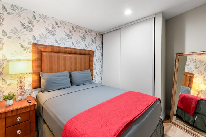 Habitación privada tipo casita con cama queen, elegante papel tapiz floral, vestidor y baño privado: perfecta para disfrutar de total independencia.