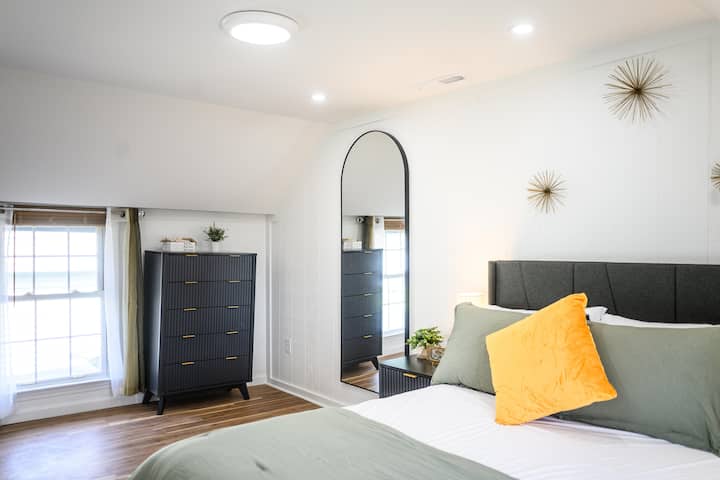 Enjoy a restful night in this cozy room featuring a comfy full-size bed, ample cabinet storage, and a convenient mirror to check your look before heading out.