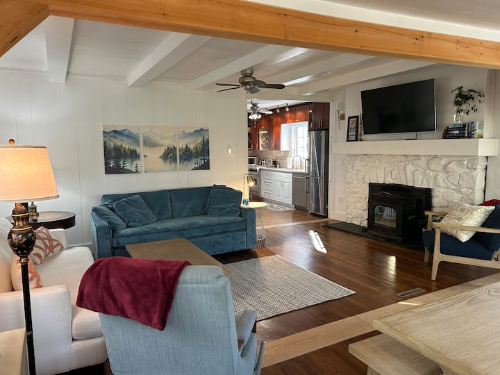 Svijetao, otvoren dnevni boravak s udobnim prostorom za sjedenje, izloženim gredama i jednostavnim pristupom kuhinji.