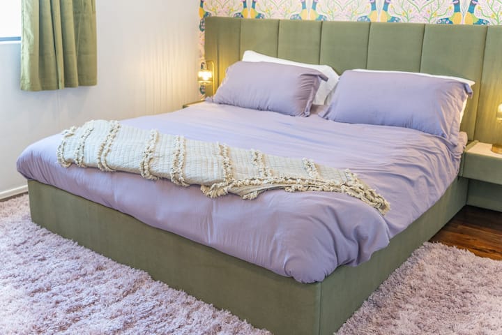 Unwind in this cozy retreat featuring a plush king bed, soft lilac tones, and calming decor — the perfect spot to relax and recharge after a day of  sunshine and adventure.