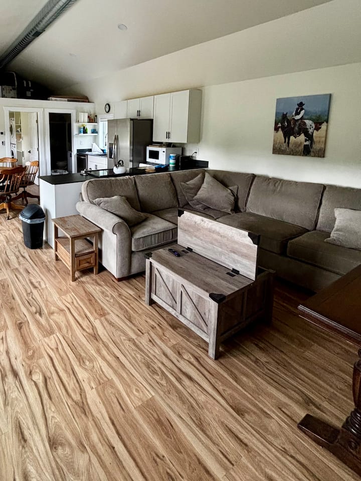 Otvorený obývací priestor/kuchyňa s klenutým stropom.  Veľká pohodlná sedacia súprava s výsuvnou posteľou.