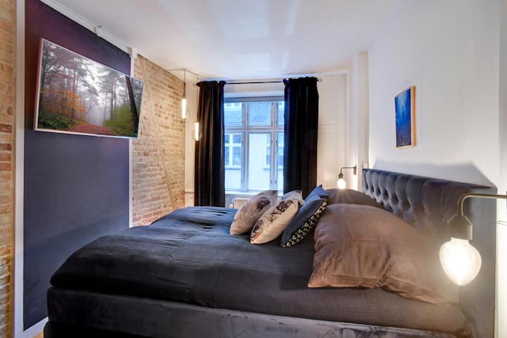 Kitanda kikubwa sana chenye starehe, kabati lenye viango, rejeta, pazia za ngazi mbili kwa ajili ya giza kamili na runinga ya skrini bapa yenye huduma za kutazama video mtandaoni. 