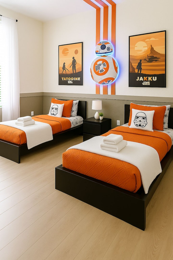 Детска спалня с тематика „Междузвездни войни“ близо до „Дисни“ с две единични легла, стенна декорация с BB-8 с LED осветление и плакати с Татуин и Джаку. Чисти чаршафи и кърпи с хотелско качество, модерно нощно шкафче и естествена светлина. Забавна стая с галактическа тематика, идеална за семейства!