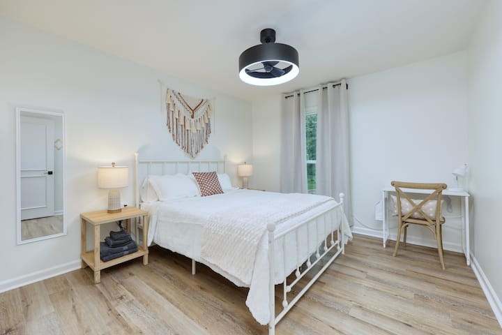 Manželská posteľ a stôl. Skriňa s regálom na batožinu, vešiakmi a košom.