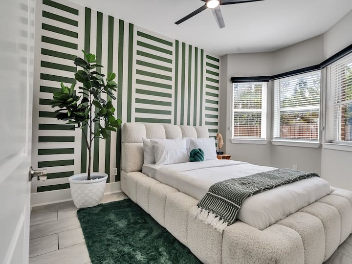 Პირველ საძინებელში წარმოდგენილია გლუვი თანამედროვე დეკორი, რომელიც კარგად მოფიქრებული გაუმჯობესებულია მწვანე აქცენტებით, რაც გამაგრილებელ ფერს მატებს. Ეს კომბინაცია ქმნის ცოცხალ, თუმცა დამამშვიდებელ ატმოსფეროს, რაც ოთახს ელეგანტურად, დამამშვიდებლად და შინაურულად აქცევს.