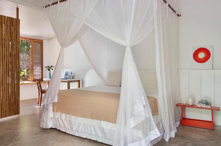 Просторен и проветрив апартамент с легло с балдахин и минималистичен декор, който съчетава дърво, занаяти и естествена светлина – убежище на комфорт и спокойствие сред природата.