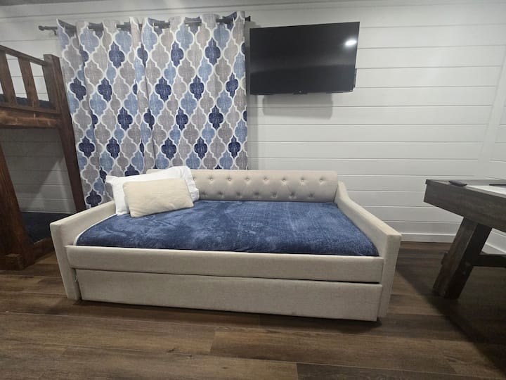 Cozy daybed with trundle and TV—restful, homey retreat for relaxing stays.