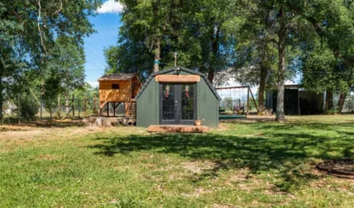 Foto exterior de la oficina independiente. Este espacio tiene una cerradura en la puerta para mayor privacidad, un mini split para calefacción y refrigeración, una chimenea eléctrica y un televisor. 