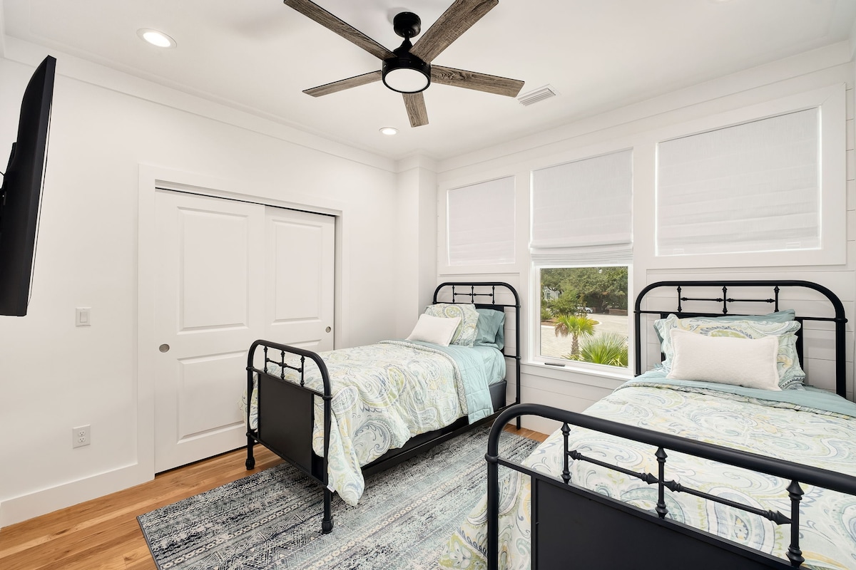 Მე-2 სართულზე ორი ტყუპი საწოლი ტუმბოებით, კარადა საკიდებითა და ტელევიზორით.