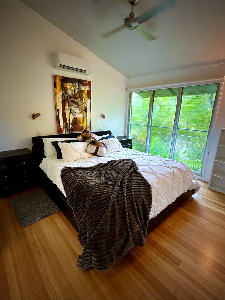 Ovo je glavna spavaća soba koja ima vlastitu kupaonicu. Nalazi se na gornjem katu. Lijepa svježa posteljina, australska umjetnička djela, zvukovi mora i pogled na zelenilo obogatit će svaki trenutak hedonističkog opuštanja! Klimatizacija u ovom području. 