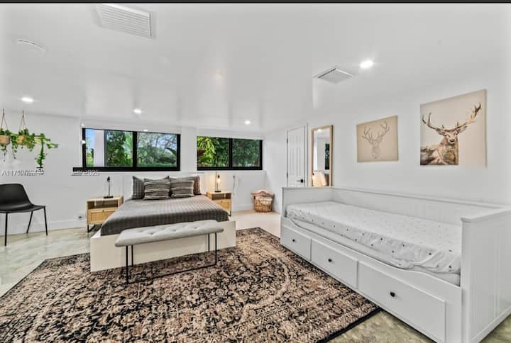 Пространа спална соба со брачен кревет (широк 150-179 см), дневен кревет и сопствена бања. Големите прозорци внесуваат природна светлина, додека удобниот килим и декорот инспириран од природата создаваат топло, привлечно место за одмор.

