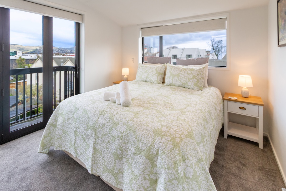 Просторна спалня с чисто спално бельо и красив изглед