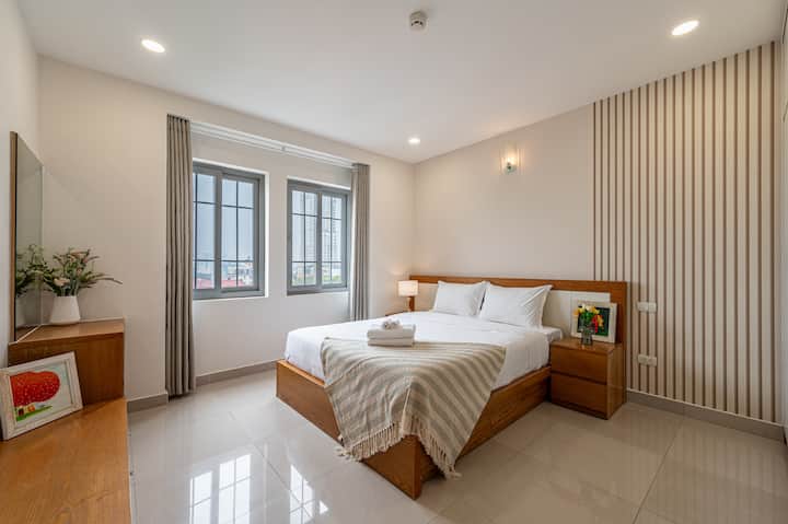 Ფართო და ელეგანტური საძინებელი – დიდი ფანჯრებით, ბუნებრივი განათებით, პლუშის საწოლითა და გლუვი ხის ავეჯით, ეს ოთახი იდეალურია სტუმრებისთვის, რომლებსაც სურთ როგორც დასვენება, ისე ფუნქციონირება მე-2 რაიონში.