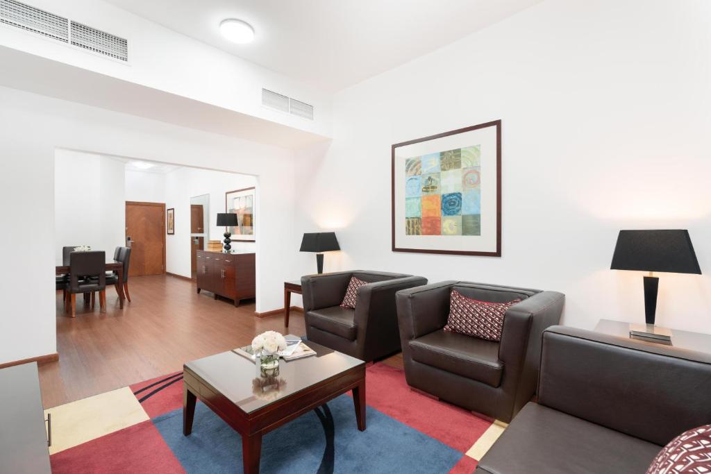 Sala de estar luminosa con un cómodo sofá, una elegante mesa central y un escritorio de trabajo adicional designado, perfecto para relajarse, trabajar o disfrutar de tiempo de calidad durante tu estancia.