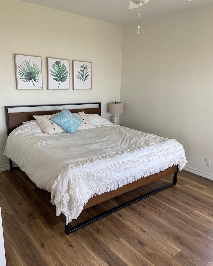 Udobna spavaća soba za goste s bračnim krevetom i prekrasnim pogledom na plažu kroz staklena vrata – savršeno mjesto za buđenje uz zvuk valova.