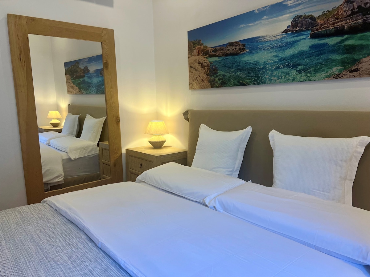 Cama doble tamaño king con colchón alto y reposacabezas.