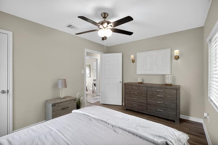 Hauptschlafzimmer mit Queensize-Doppelbett
Elegantes Hauptschlafzimmer mit Queensize-Bett, Deckenventilator und Kommode, das einen ruhigen Raum für erholsame Nächte in Houston bietet