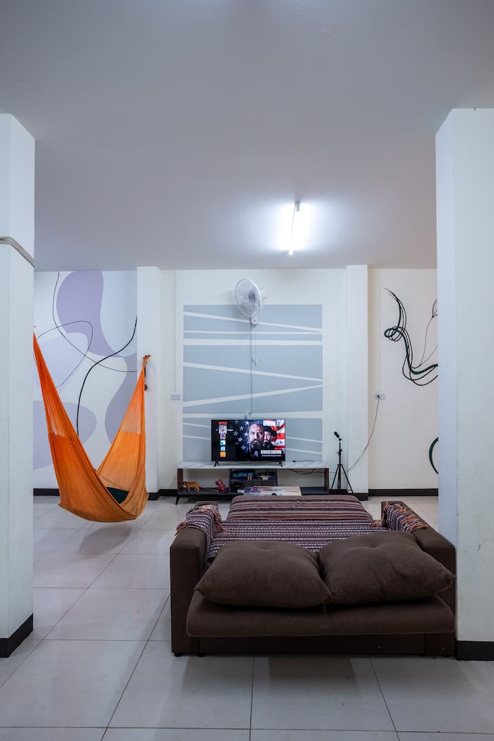 De bank heeft dekens, kussens en lakens onder de trap met de yogamatten. De bank is geschikt voor 2 volwassenen en is een tweepersoonsbed.