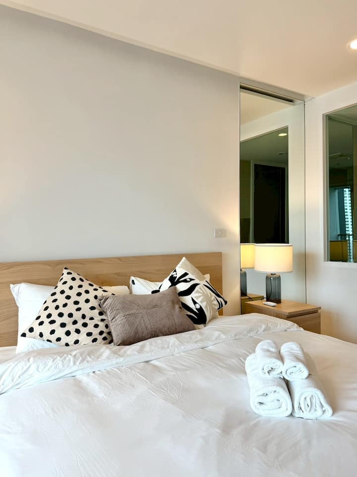 This serene bedroom offers a large, plush bed, stylish pillows, and warm bedside lighting—ideal for winding down in total comfort.