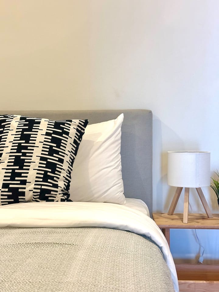 Drift into deep sleep on a plush, hotel-quality bed topped with crisp linens and stylish monochrome cushions.
