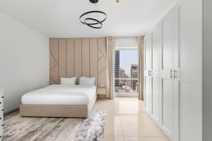 ️ 明亮的卧室，配有米色软垫床、洁白的床单、现代内置衣柜和时尚的黑色天花板灯。 大窗户可欣赏城市景观，自然光线充足，增强了房间的通风和优雅氛围。