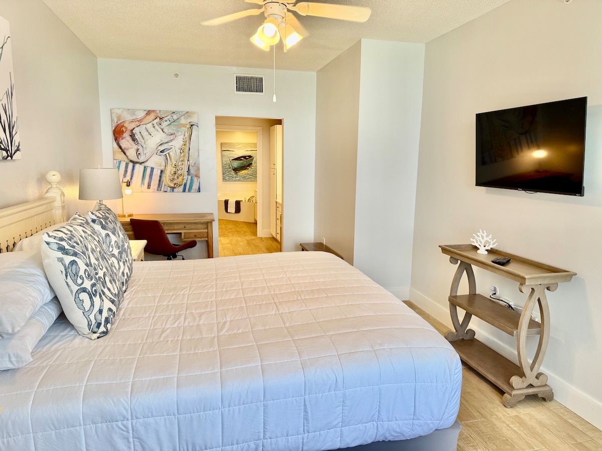 დიდი ძირითადი საძინებელი, სადაც არის სატვირთო საწოლი, სტრიმინგის სერვისების მქონე სმარტ‑ტელევიზორი და სამუშაო სივრცე. აივნისკენ მიმავალი კარი, საიდანაც მე‑10 სართულიდან შესანიშნავი ხედი იშლება. 