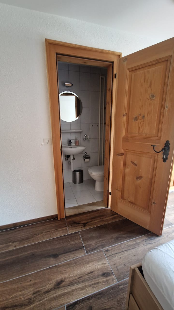 El baño en suite en la habitación de slalom, con ducha e inodoro.