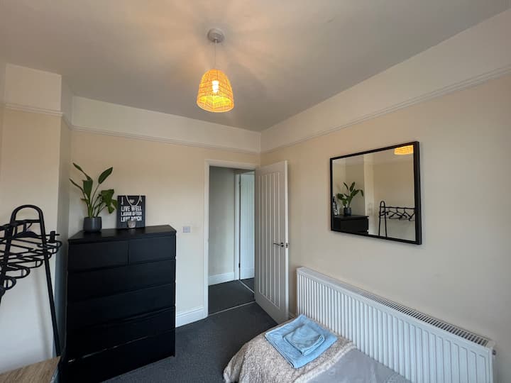 Удобна, евтина единечна соба. 
Мал единечен кревет на спуштање, шипка за алишта и закачалки, комплет фиоки, биро и стол со ламба. Има поглед кон западната градина со јаболка 