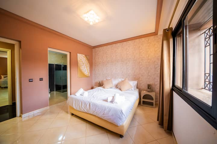 Chumba cha kulala angavu chenye kitanda kizuri na mapambo ya kisasa ya ukuta.
