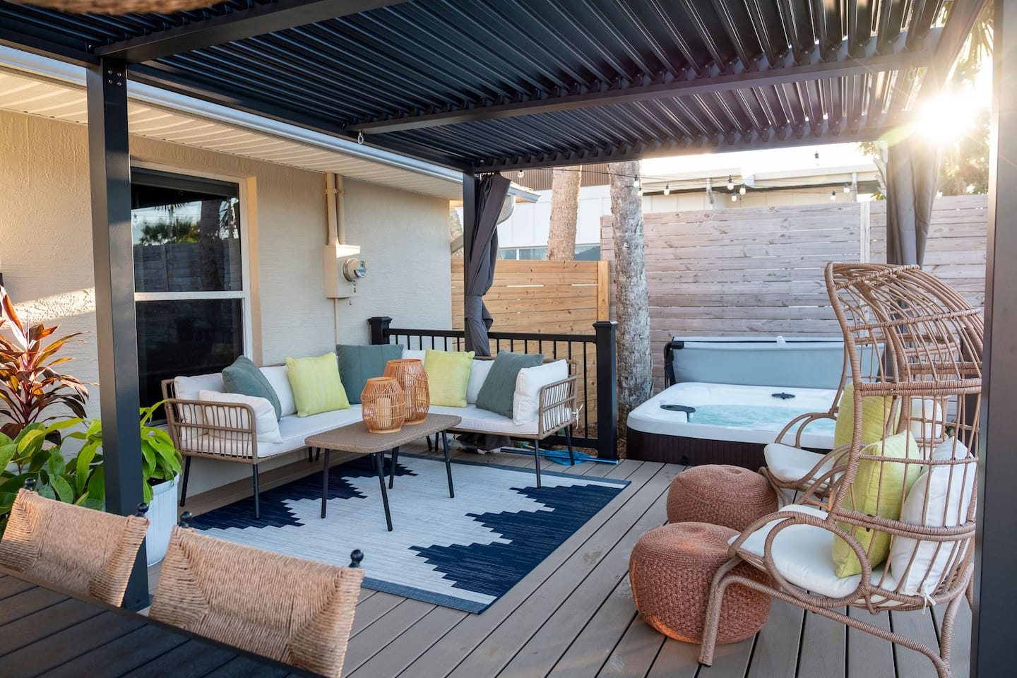Covered back deck with outdoor sofa, egg chairs and the hot tub