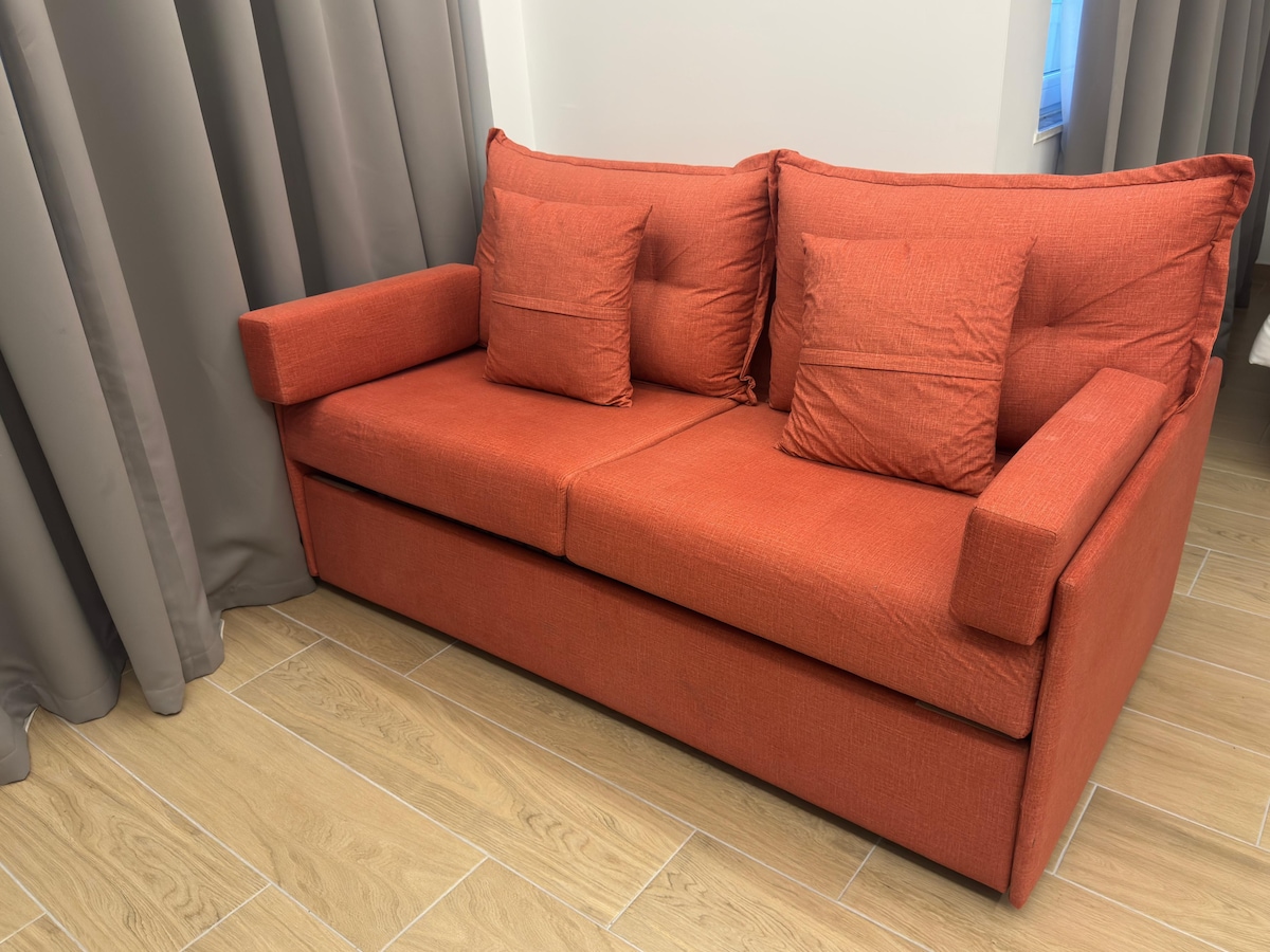 El acogedor sofá se convierte en una cama, combinando estilo con comodidad.