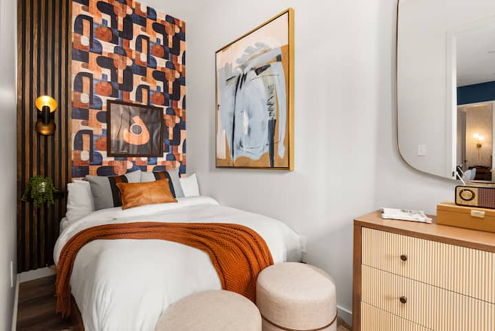 Elegante segundo dormitorio con una cómoda cama de tamaño completo, ropa de cama mullida y estilo boutique Music Row.  Con cortinas opacas y un reloj despertador con reducción de ruido escondido en el cajón superior de la cómoda para una noche de sueño tranquila y reparadora.