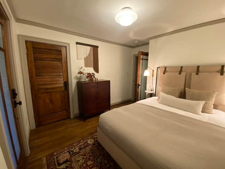 Dormitorio II: completo con una cama tamaño queen con ropa de cama de algodón 100% orgánico, colchón de látex natural sostenible, armario + acceso directo a la terraza trasera cubierta donde puedes disfrutar de comidas al aire libre o sentarte con tu portátil en una mesa de encimera para dos. 