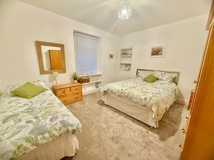 Долна спална соба со 1 брачен кревет и 1 единечен кревет. Мала тема за крави во Хајленд!