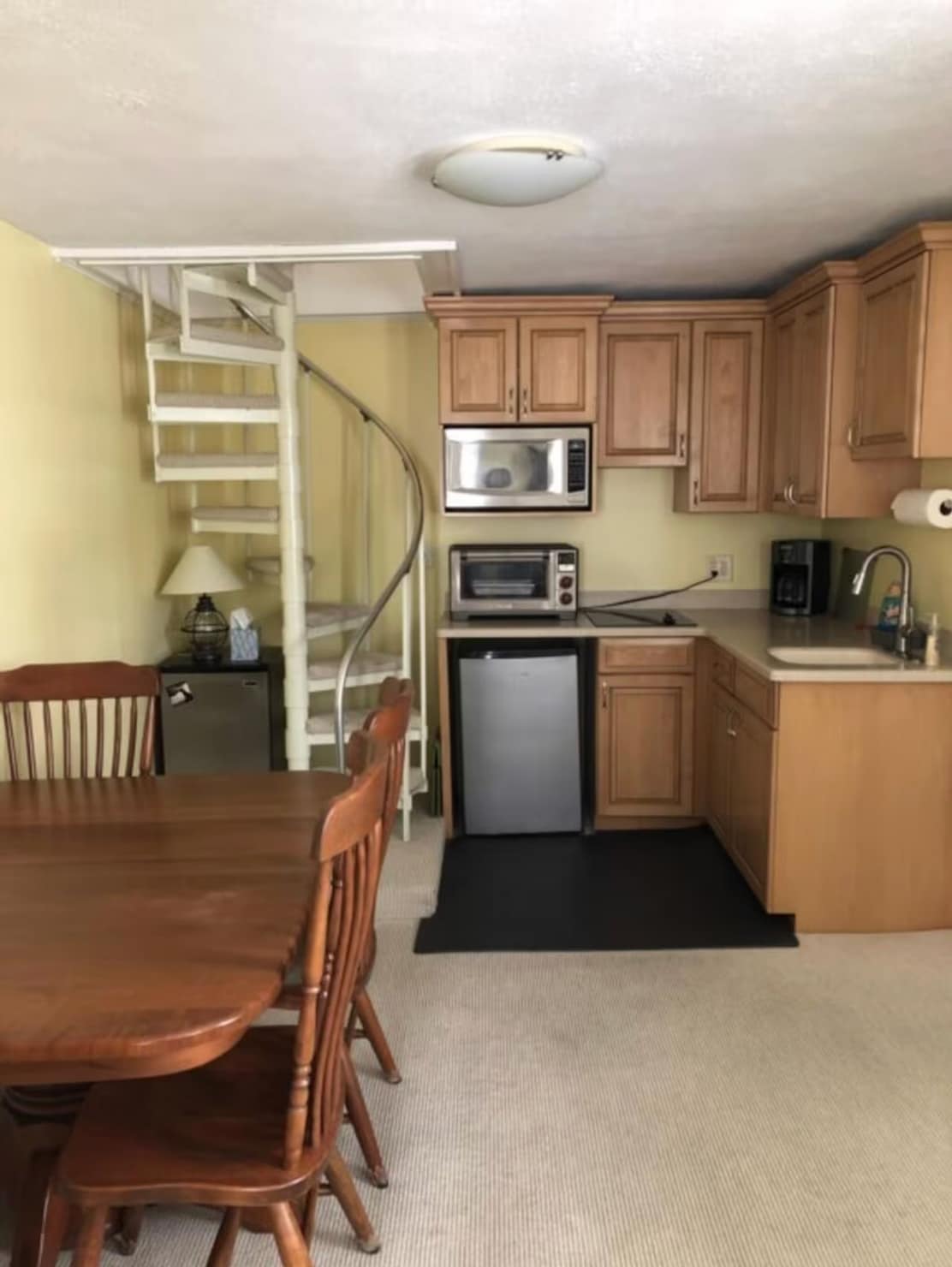Updated kitchen with original spiral staircase — period charm meets modern stay