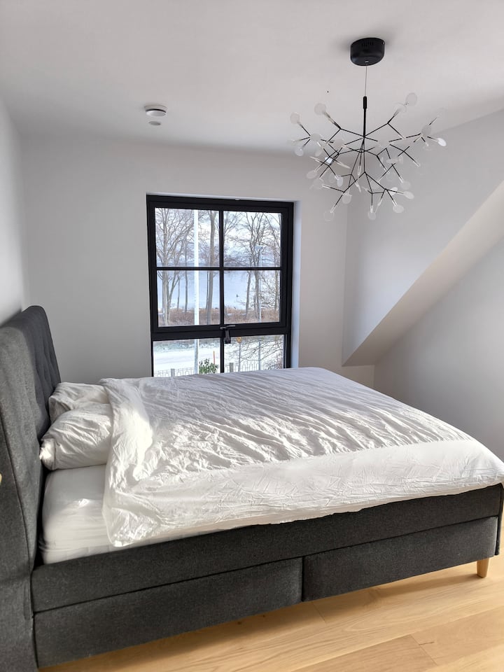 El dormitorio 2 viene con una cama doble y dos grandes ventanas orientadas al este (vista al mar) y al sur.