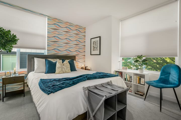 Стилска гостинска спална соба со шарени акценти и удобна постелнина.