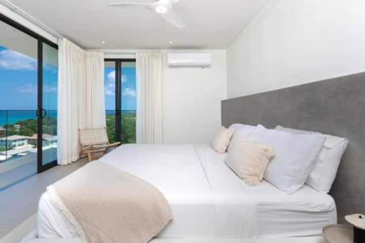 Sensational master bedroom with a private terrace with stunning sea views, air conditioning, ceiling fan and a beautiful en suite bathroom with freestanding outdoor bath, walk in shower and twin basin.
