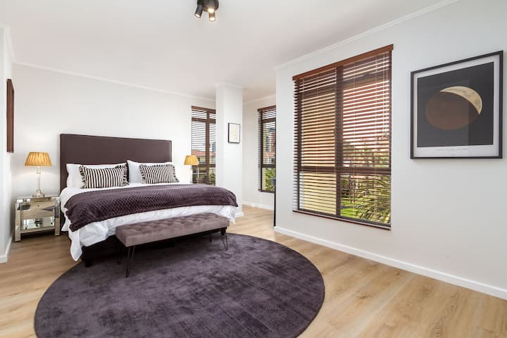 Основната спалня предлага панорамна гледка към канала и палмите, което създава спокоен и живописен фон. Големите прозорци пропускат много естествена светлина, което прави помещението идеално за събуждане с нови сили.