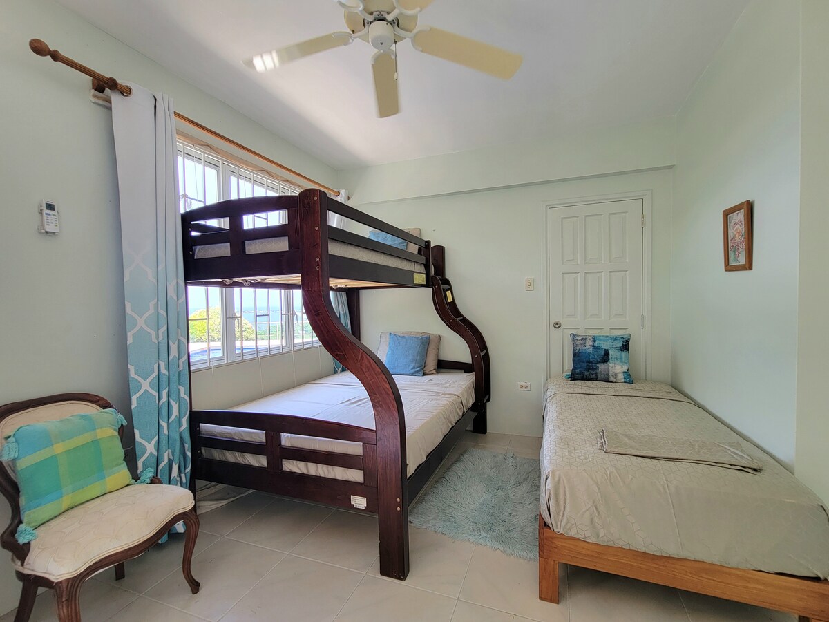 Krevet na kat i krevet za jednu osobu u spavaćoj sobi s kupaonicom na donjem katu