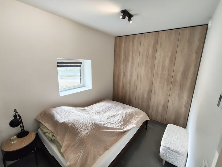 Მყუდრო საძინებელი ორადგილიანი საწოლით, ნეიტრალური თეთრეულით, ჩაშენებული ხის კარადებით და პატარა ფანჯრით, საიდანაც იშლება ბუნებრივი სინათლე ტბის ხედით